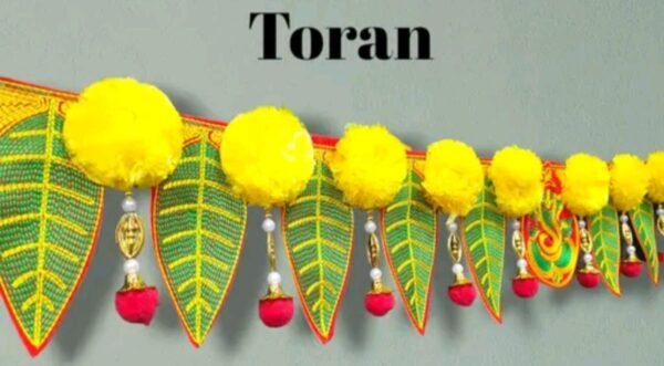 Close-up view of handcrafted mango pan toran showcasing intricate green leaf embroidery with yellow veins and red edges.